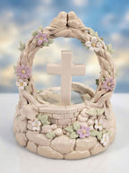 Decorative stone sculpture with a cross and floral elements against a blurred natural background